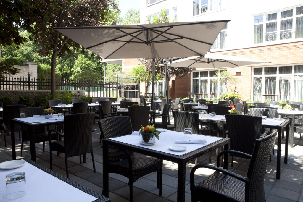 Savourez un délicieux repas sur la terrasse du restaurant Oskar au coeur des jardins de l'hôtel